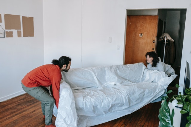 A Couple Lifting A Couch