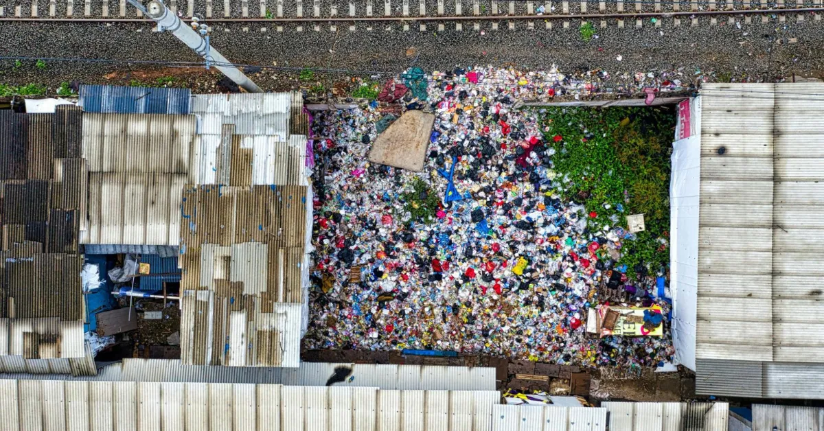An aerial shot of a poor neighborhood with a waste disposal area.