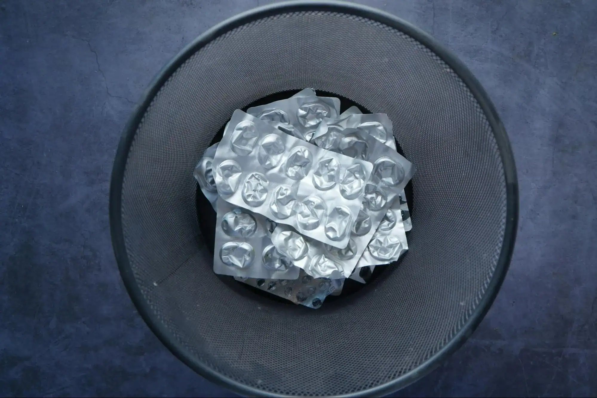 Pharmaceutical waste in a trash bin, indicating the importance of safe disposal for the environment.