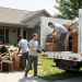 View of professional hauling crews loading furniture and boxes into a dump truck on a residential driveway, illustrating the labor and service components that factor into the average price per hour for junk removal budgeting.