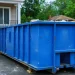 Image of a 30 cubic yard dumpster parked at a residential construction site, showing size dimensions and large capacity for home renovation or debris removal projects