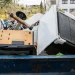 Image of a dumpster filled with household junk and appliances, representing cheap junk removal and hauling services near me with fast, affordable pickup.