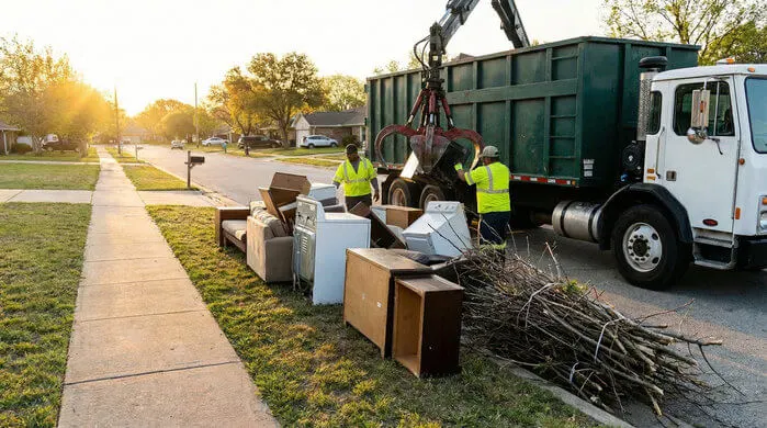 An image of bulk trash pickup and removal service near me collecting large furniture, appliances, and yard debris from curbside for bulk waste and junk collection