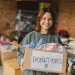 An image of a woman holding a donation box filled with clothes during home decluttering, illustrating a room by room checklist and whole house organization guide