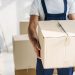 An image of a moving cleanout service worker carrying a cardboard box during junk removal and decluttering before a move