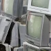 An image of old CRT and flat-screen televisions stacked for recycling, illustrating how to dispose of an old TV through electronics recycling centers, manufacturer take-back programs, donation options, or professional TV pickup and disposal services.