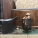 An image of an old backyard hot tub and wood-fired heater system ready for removal.