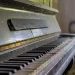 An image of a dusty upright piano showing signs of age and wear for removal and disposal.