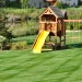 An image of a backyard wooden playset with swings and a slide for professional swing set removal and haul-away services.