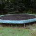 An image of an old backyard trampoline ready for trampoline removal, highlighting the need for safe disassembly, hauling, recycling, and disposal services.