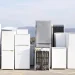 An image of old refrigerators gathered at a recycling facility, illustrating how to dispose of a refrigerator in Toledo through responsible appliance recycling or junk removal services.